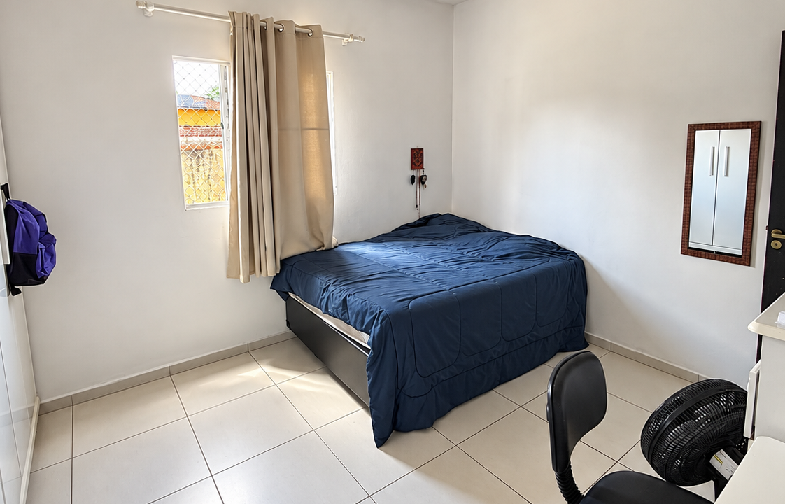 Quarto minimalista com cama azul e luz natural