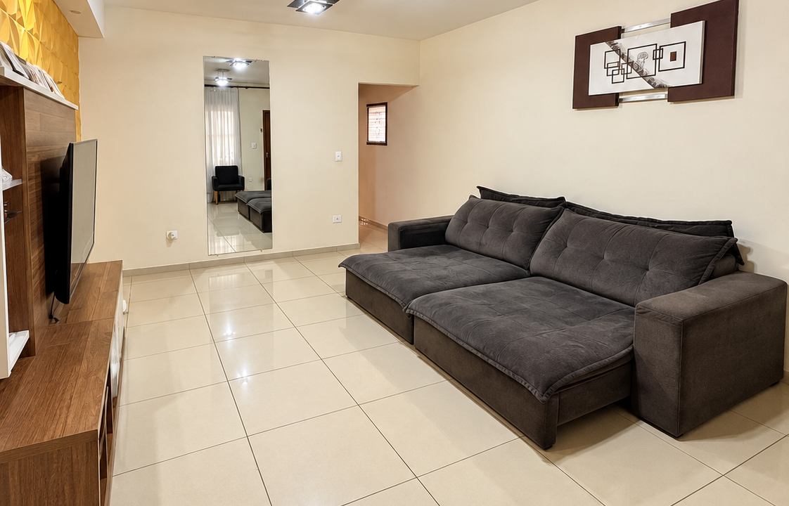 Sala moderna com sofá escuro e TV